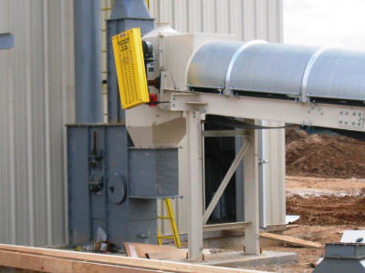 Covered troughing belt conveyor with head box enclosure transferring to the boot of a bucket elevator.