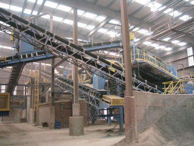 Turnkey clay grinding plant with multiple crushers, screens, conveyors and storage silos.  It was designed to fit within the confines of an existing building to service two clay brick manufacturing plants simultaneously.