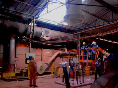 Setting the base section of a 101' freestanding exhaust stack through the roof of a building.