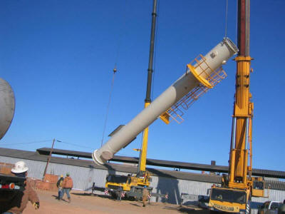 Lifting the base section of a 101' freestanding exhaust stack which was pre-assembled with test ports, access caged ladder and 1/3 circumference testing platform.