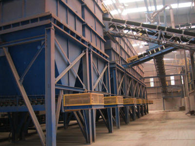Back view of eight 150 ton capacity clay product storage silos with integral 42” wide belt feeders feeding a gathering conveyor.